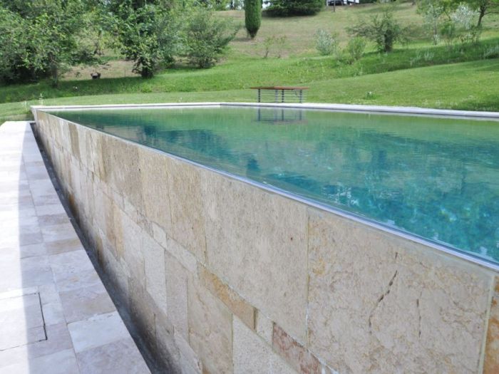 Archisio - Studio Lenzi Associati - Progetto Piscina e spogliatoio in pietra in collina